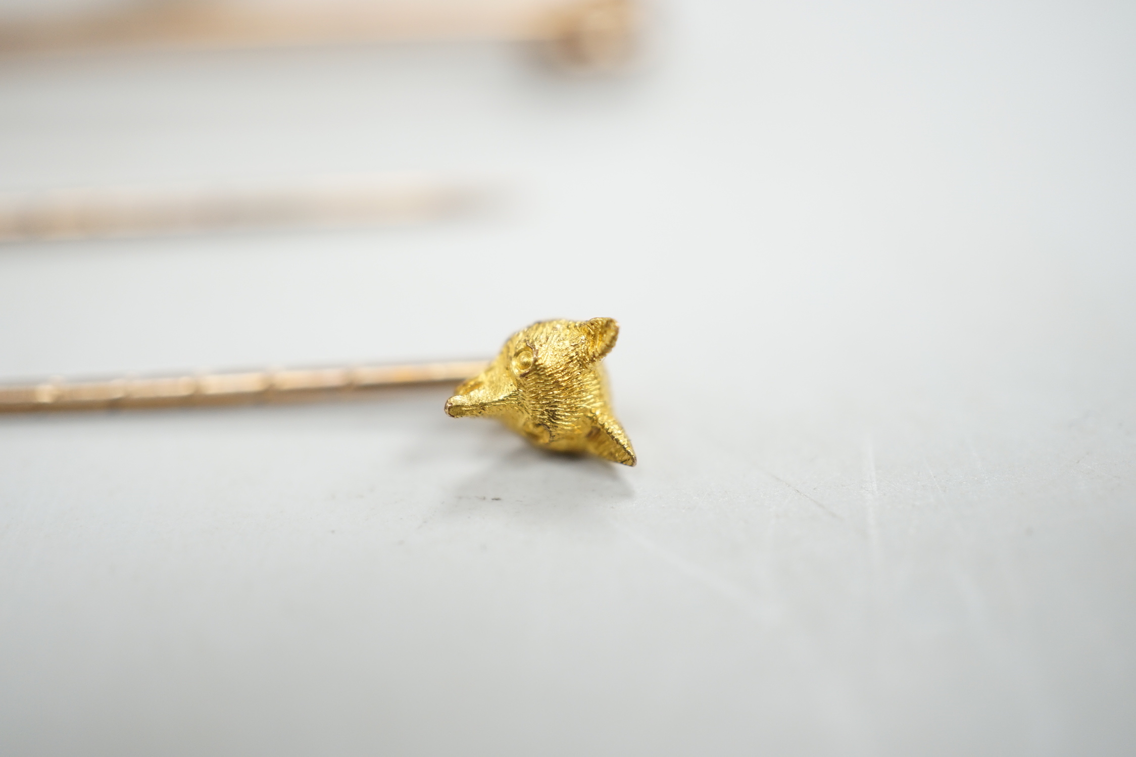 A Victorian yellow metal and diamond cluster set fox head pin, 44mm, two other fox head pins and a 15ct fox head and hunting horn brooch, gross weight 8.5 grams.
